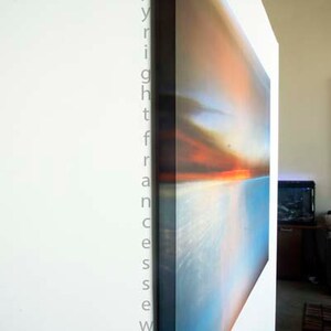 K&ouml;nnte beinhalten: Ein gro&szlig;es abstraktes Leinwandbild mit einem Farbschema in Blau, Orange und Wei&szlig;. Das Bild h&auml;ngt an einer wei&szlig;en Wand.