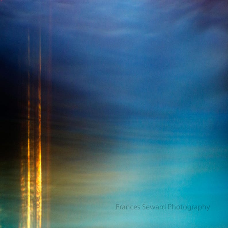 K&ouml;nnte beinhalten: Abstrakte Fotografie eines verschwommenen blauen und gelben Himmels mit einem goldenen Lichtstreifen in der Mitte.