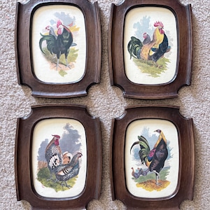 May include: Four framed rooster prints with dark wood frames. Each print features a colorful illustration of a rooster or chickens in a pastoral setting. The frames have a unique, curved shape.