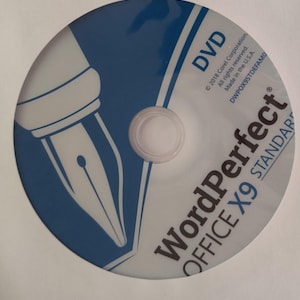 Puede incluir: Un DVD circular con un diseño en azul y blanco que incluye el gráfico de una punta de pluma estilográfica. El texto dice WordPerfect OFFICE X9 STANDARD, DVD, 2018 Corel Corporation, All rights reserved, Made in the U.S.A. y DWPOX9STDEFAMO.
