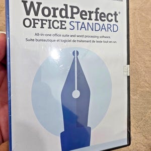 Puede incluir: Una caja de software Corel WordPerfect Office Standard con una cubierta blanca que presenta un gráfico de plumín de pluma estilográfica azul. El texto dice Corel, WordPerfect OFFICE STANDARD, LATEST VERSION INCLUDED y software.