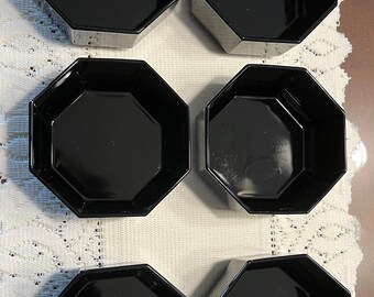 May include: Set of six black octagonal bowls. The bowls are made of glass and have a smooth, glossy finish.