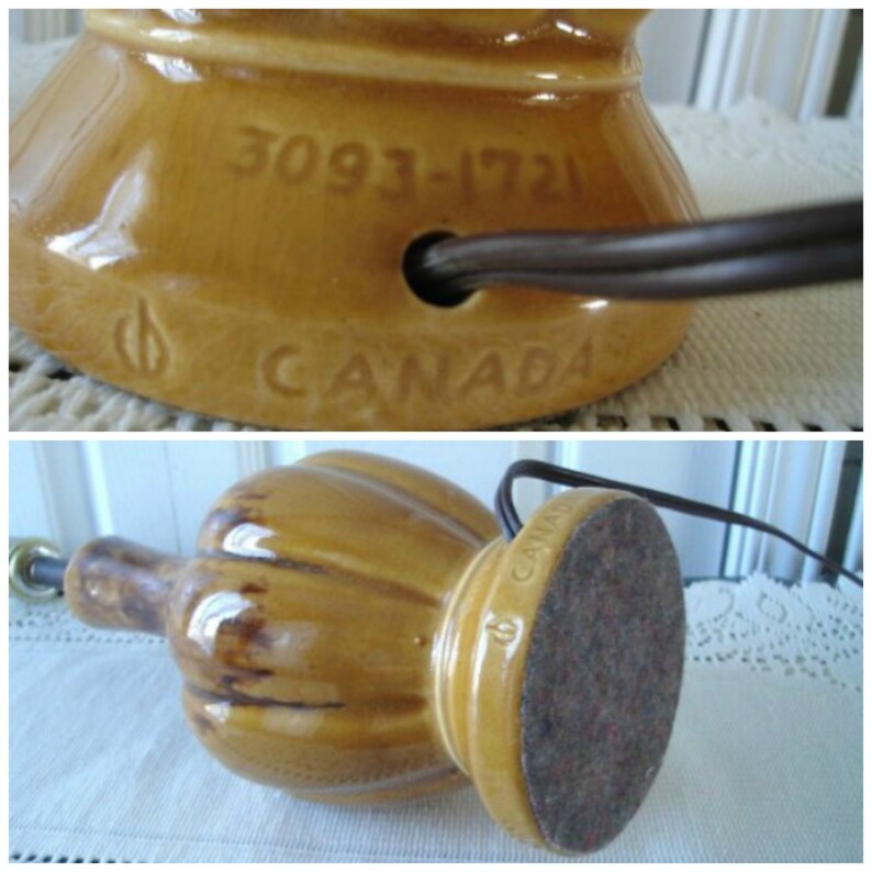 May include: A brown ceramic table lamp with a ribbed design and a round base. The lamp has a cord and a plug. The base is marked with the number "3093-1721" and the word "CANADA".