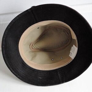 May include: A black felt fedora hat with a tan fabric lining. The hat has a small label inside that reads "Made in Italy".