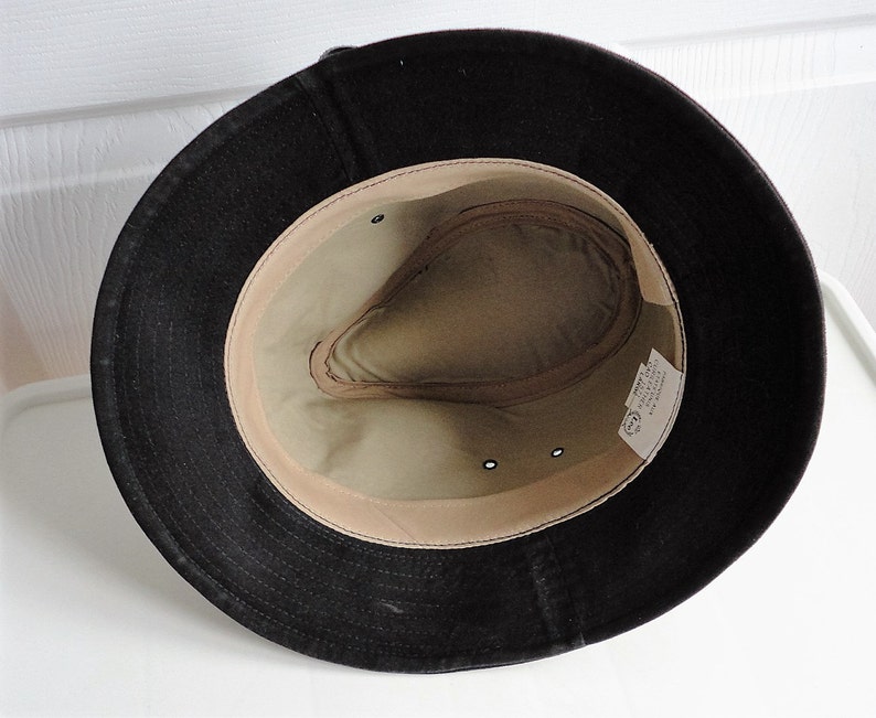 May include: A black felt fedora hat with a tan fabric lining. The hat has a small label inside that reads "Made in Italy".
