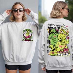 May include: White sweatshirt featuring a graphic of Oogie Boogie from The Nightmare Before Christmas. The front has a circular design with text and the character. The back has a larger design with Oogie Boogie and text.