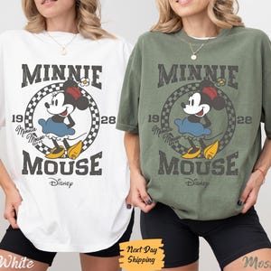 K&ouml;nnte beinhalten: Zwei T-Shirts mit einem Vintage-Grafik von Minnie Mouse. Das wei&szlig;e T-Shirt hat schwarzen Text, der "Minnie Mouse" und "Disney" sagt. Das gr&uuml;ne T-Shirt hat schwarzen Text, der "Minnie Mouse" und "Disney" sagt.