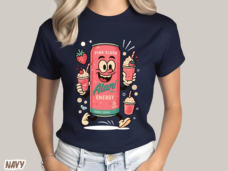 May include: Navy blue t-shirt featuring a cartoon illustration of a pink energy drink can with a smiling face, holding strawberry smoothies. The can is labeled "Alari Energy" and "Pink Slush". The shirt is a crew neck.