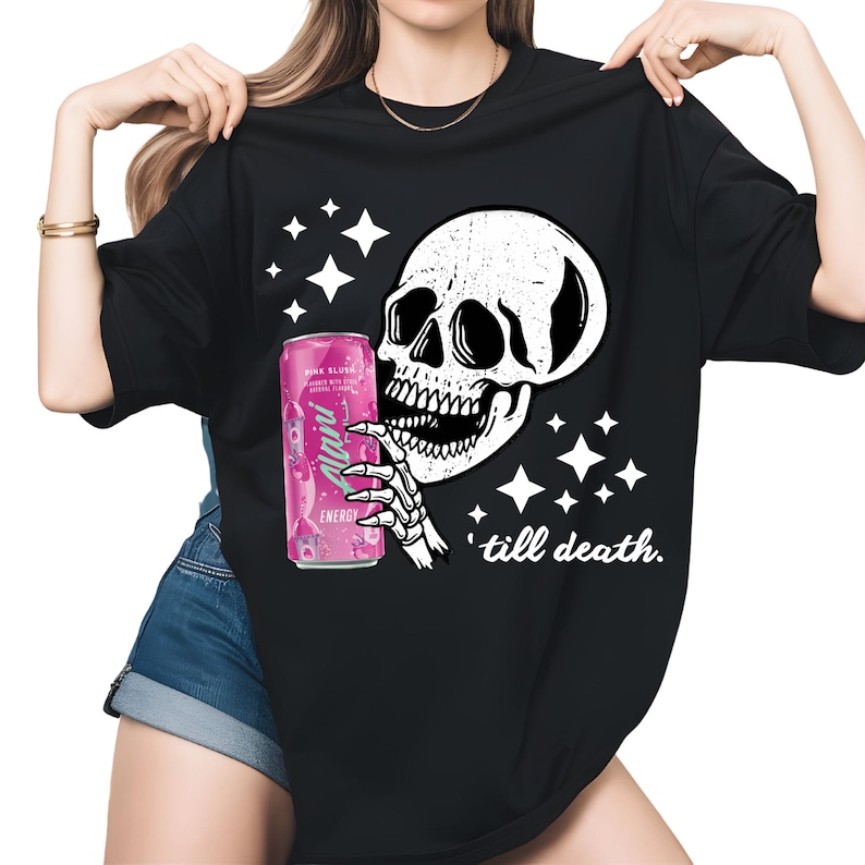 May include: Black t-shirt featuring a white skull graphic holding a pink energy drink can. The design includes white stars and the phrase "'till death." The can has the text "Alani Energy".