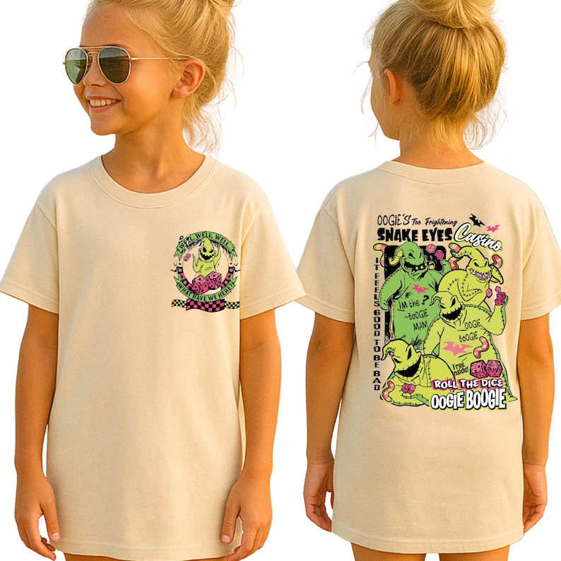 May include: A beige t-shirt featuring a graphic of Oogie Boogie from "The Nightmare Before Christmas." The front has a small circular design with text, while the back displays a larger image with the words "Oogie's Snake Eyes Casino."