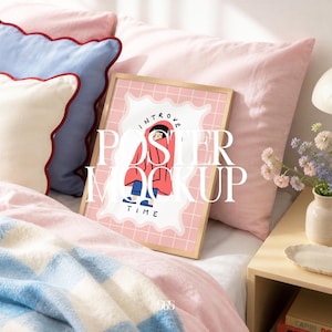 Op de afbeelding: Een ingelijste poster-mockup met een cartoonillustratie van een persoon in een rode deken. De poster ligt op een bed met roze en blauwe kussens en een geruite deken. De tekst op de poster luidt "Introvert Time" en "Poster Mockup".