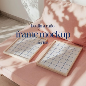 May include: Two wooden picture frames with a grid pattern on a pink sofa. The frames are empty and ready for your photos. The text "iso din a ratio frame mockup no. 108" is visible in the image.
