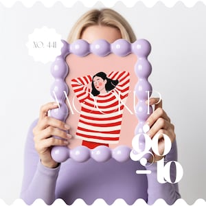 Könnte beinhalten: Ein lila Rahmen mit einem Blasendesign hält ein rosa Bild einer Person in einem rot-weiß gestreiften Pullover. Der Rahmen trägt die Texte "MOCKUP" und "90-10". Das Bild hat auch den Text "NO. 441".