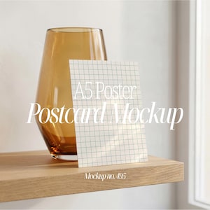Puede incluir: Maqueta de un póster o postal A5 con patrón de cuadrícula, colocada sobre una estantería de madera. El texto "A5 Poster Postcard Mockup" se muestra en la tarjeta. Un jarrón de cristal marrón está detrás de la tarjeta. El texto "Mockup no. 495" está en la parte inferior.