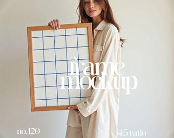 May include: A person holds a wooden frame with a white background and blue grid lines. The frame is 4:5 ratio and is labeled "no. 120". The text "frame mockup" is superimposed on the image.