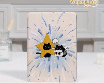 Pode incluir: Uma peça de arte retangular em madeira com uma ilustração fantasiosa. Uma estrela amarela com olhos de gato pretos e um gato preto numa caixa são colocados num fundo de fogos de artifício azuis e brancos. A obra de arte é assinada "Wupong Art".