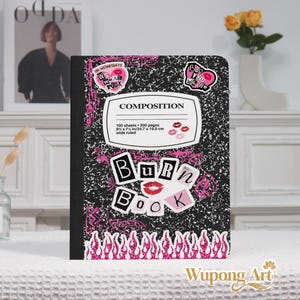 May include: Composition notebook with a black and white speckled design. The cover features pink accents, the words "Burn Book," and stickers with phrases like "On Wednesdays We Wear Pink." The notebook measures 9 3/4 x 7 1/2 inches.