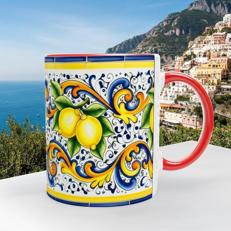 Peut inclure: Un mug en c&eacute;ramique orn&eacute; d'un motif color&eacute; de citrons jaunes et de feuilles vertes sur fond blanc, agr&eacute;ment&eacute; de volutes bleues et jaunes. Ce mug pr&eacute;sente une anse rouge unie ainsi qu'un bord rouge, mettant en valeur un d&eacute;cor peint d&eacute;taill&eacute;.