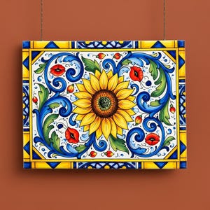 Può includere: Piastrella in ceramica rettangolare con un girasole centrale, circondato da motivi floreali blu, verdi e rossi. Il bordo è giallo con dettagli blu. L'opera è sospesa da un sottile filo metallico.