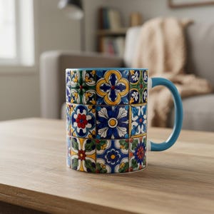 Könnte beinhalten: Ein Keramikbecher mit einem lebendigen Raster aus farbenfrohen Blumen- und geometrischen Mustern in Blau-, Gelb-, Grün- und Rottönen. Der Becher hat einen einfarbigen hellblauen Henkel und einen passenden hellblauen Innenrand mit Fliesenmuster.