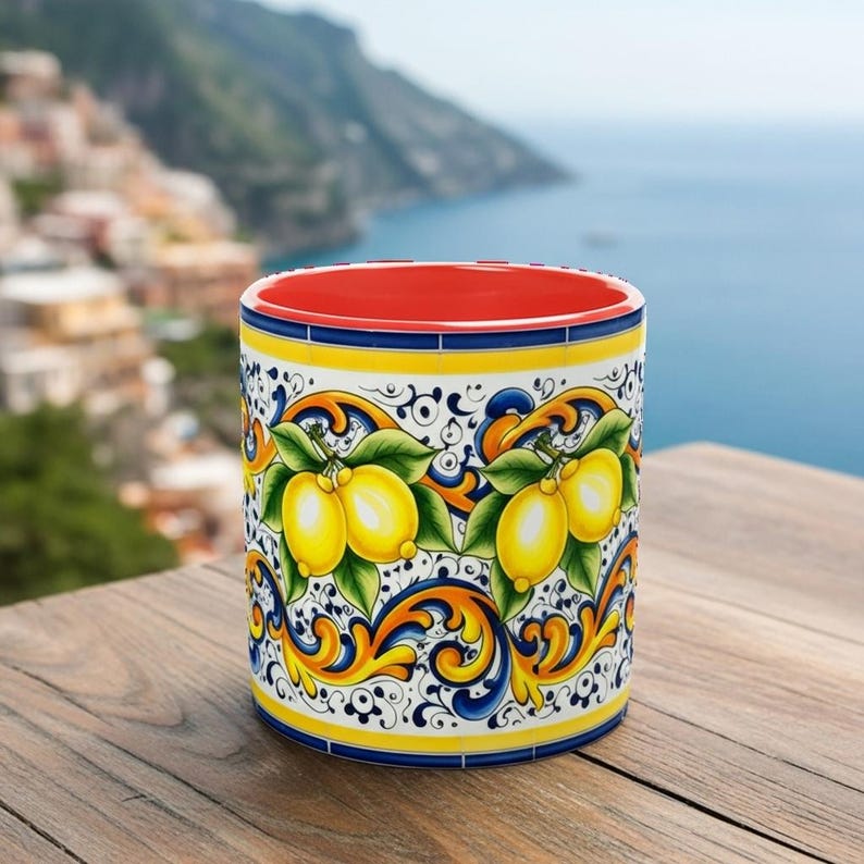 Peut inclure: Un mug cylindrique en c&eacute;ramique orn&eacute; d'un motif vif de citrons jaunes avec des feuilles vertes, sur un fond blanc avec des volutes bleues et orange complexes. L'int&eacute;rieur du mug est d'une couleur rouge vif et unie.