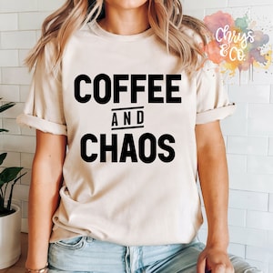 Pode incluir: Uma camiseta bege com texto preto que diz "COFFEE AND CHAOS".