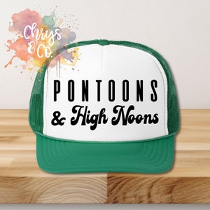 May include: A white and green trucker hat with the text "PONTOONS & High Noons" in black.