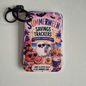 May include: A set of Summerween Savings Trackers cards on a black plastic ring. The cover features a beach scene with a ghost, a jack-o'-lantern, a sandcastle, and watermelon, with the text "SUMMERWEEN SAVINGS TRACKERS 6 TRACKERS 6 SAVINGS GOALS SAVE A LITTLE MAGIC ALL SUMMER LONG."