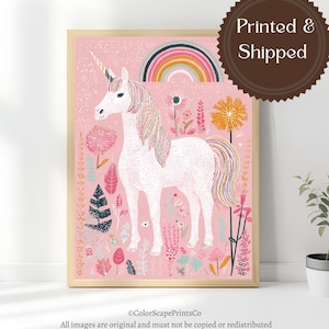 May include: A framed print featuring a white unicorn with a golden horn, a rainbow, and floral elements on a pink background. The artwork includes the text "Printed & Shipped". The print is in a wooden frame.