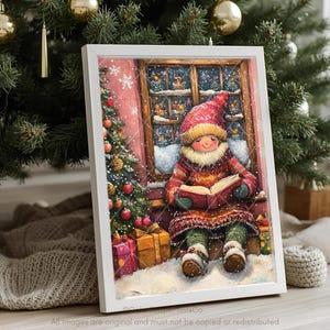 May include: A framed print showing a child in winter clothes reading a book by a snowy window. The child wears a red hat and sweater, with a Christmas tree and wrapped gifts nearby. The artwork has a cosy, festive theme.