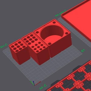 May include: Five red plastic organizers with different compartments and shapes. The organizers are designed for storing small items like pens, pencils, and other office supplies.