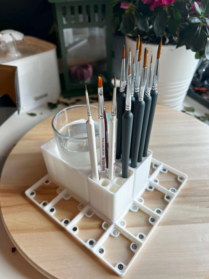 Puede incluir: Portacepillos de pintura de pl&aacute;stico blanco con m&uacute;ltiples ranuras para cepillos. El soporte tiene un vaso de vidrio transparente para agua y una base con m&uacute;ltiples ranuras para otros suministros. El soporte est&aacute; lleno de una variedad de pinceles.