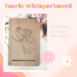 Peut inclure: Une planche en bois rectangulaire présentant une illustration au trait brun foncé d'une silhouette ailée assise sur une branche. La planche comprend une fente horizontale près du bas et une petite icône de papillon. Le texte indique faerie whisperboard.