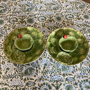 May include: Two green ceramic serving dishes shaped like artichoke leaves with a small bowl in the center. Each bowl has a red ladybug on the top.