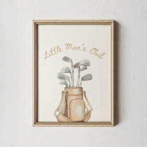 Puede incluir: Impresi&oacute;n en acuarela enmarcada de una bolsa de golf llena de palos de golf. La bolsa es de color beige con correas marrones. El texto "Little Man's Club" est&aacute; escrito en letras doradas encima de la bolsa. El marco es de color marr&oacute;n claro.