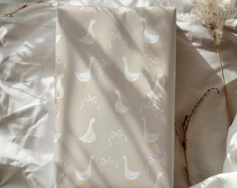 Puede incluir: Papel de regalo beige con un patrón repetitivo de gansos blancos. Los gansos miran en diferentes direcciones y tienen un diseño simple y de dibujos animados.