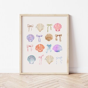 May include: A watercolour print featuring a collection of seashells in pastel pink, blue, and purple hues. Each seashell is adorned with a delicate bow in various shades of pink, blue, and green.