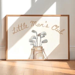Puede incluir: Impresi&oacute;n enmarcada con una ilustraci&oacute;n en acuarela de una bolsa de golf y palos. El texto "Little Man's Club" est&aacute; arqueado sobre la bolsa de golf en marr&oacute;n claro. El marco es de madera.