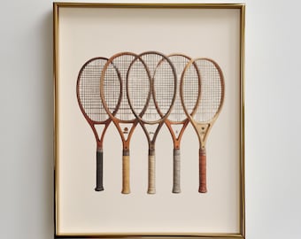 Puede incluir: Una impresión enmarcada con cinco raquetas de tenis antiguas. Las raquetas tienen marcos de madera y diferentes colores de agarre, incluyendo negro, beige y rojo. La impresión está sobre un fondo crema y enmarcada en dorado.