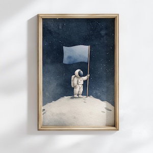 Op de afbeelding: Aquarel kunstafdruk van een astronaut op een maanachtig oppervlak, met een blauwe vlag tegen een sterrenhemel. De astronaut draagt een wit ruimtepak. Het kunstwerk is ingelijst in een goudkleurige lijst.