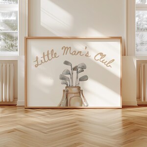 Puede incluir: Una impresi&oacute;n enmarcada con el texto "Little Man's Club" en fuente cursiva. La obra de arte presenta una ilustraci&oacute;n en acuarela de una bolsa de golf llena de palos de golf. La paleta de colores incluye tonos beige, gris y marr&oacute;n.