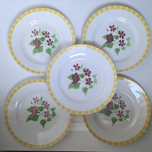 Puede incluir: Juego de cinco platos de cena de cerámica blanca con un borde rayado amarillo y blanco. Cada plato presenta un diseño floral con flores rosas y burdeos y hojas verdes.