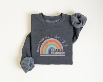 May include: A dark gray sweatshirt with a rainbow graphic and the text "Take a look, it's in a book! Reading Rainbow".