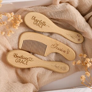 Puede incluir: Tres artículos de madera para el cuidado del cabello del bebé: dos cepillos ovalados y un peine. Los cepillos están grabados con los nombres "Charlotte Grace" y "Beatrice Grace", y el peine está grabado con "Jessica". Diseños florales están grabados en los cepillos.