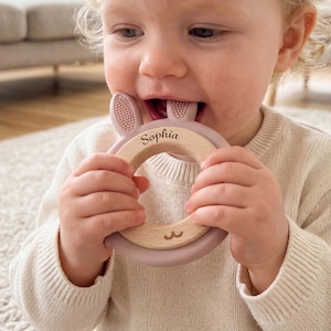 Könnte beinhalten: Ein Set aus drei Keramikbechern mit gesprenkelter, matter Oberfläche. Die Becher sind in Creme-, Hellgrau- und Dunkelgrautönen gehalten. Jede Tasse hat ein schlichtes, minimalistisches Design.