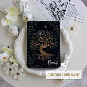 May include: A black e-reader cover featuring a gold tree of life design against a dark blue background. The name "Maria" is printed on the cover. The cover can be personalised with a name of your choice.