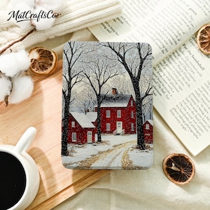May include: A rectangular metal tin featuring a winter scene with red houses and bare trees covered in snow. The illustration depicts a snowy path leading to the buildings under a pale sky. The tin has a smooth finish and rounded corners.