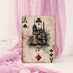 Op de afbeelding: Vintage stijl klaveren aas speelkaart met een gedetailleerde illustratie van een kasteel en bloemaccenten. De kaart heeft zwarte klaveren symbolen en de letter "A", met een verouderde uitstraling.
