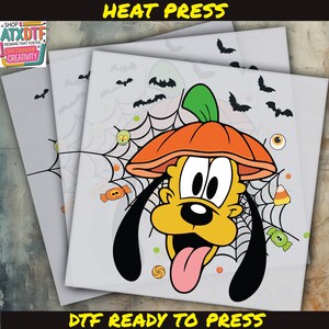 May include: DTF ready to press transfer featuring Pluto wearing a pumpkin hat, surrounded by bats, candy, and spiderwebs. The image has the text "HEAT PRESS" and "DTF READY TO PRESS" in yellow.