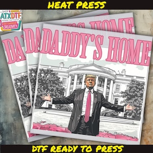 May include: A heat press ready to transfer a design onto a t-shirt. The design features a cartoon image of a man in a suit standing in front of the White House with the text "Daddy's Home".